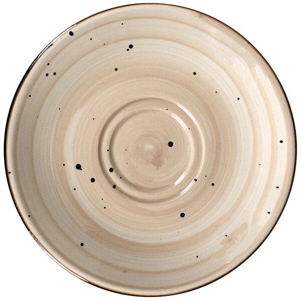 A close-up of a white porcelain saucer with black dots on it.