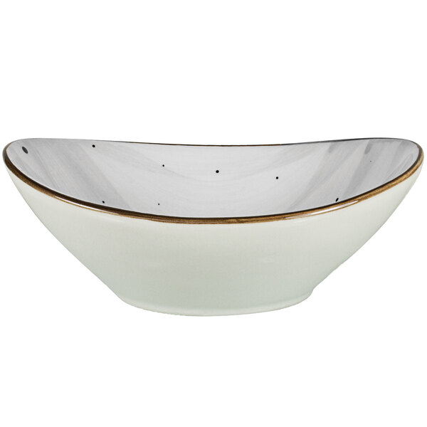 A white International Tableware oval bowl with a gold rim.