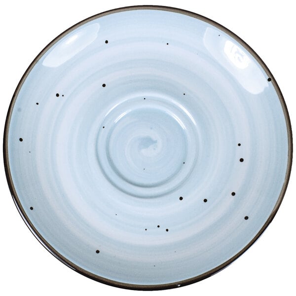 A close-up of a white International Tableware Rotana porcelain saucer with black dots on it.