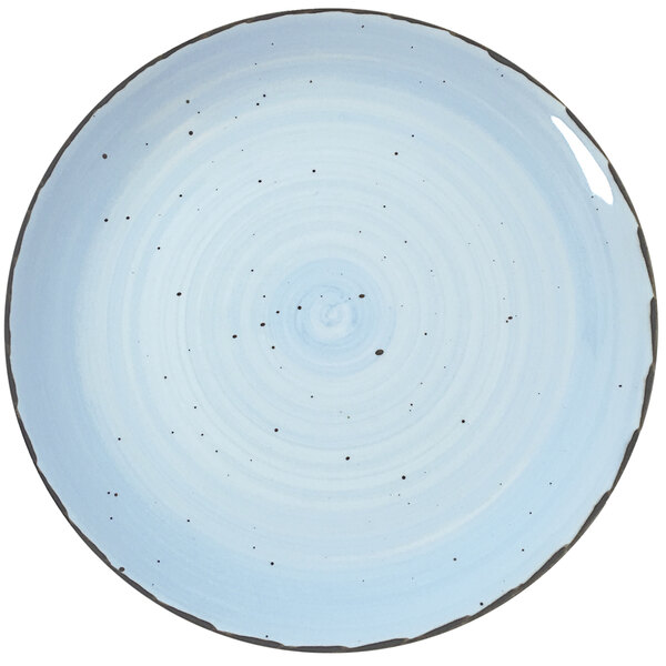 A white porcelain plate with a blue spiral pattern and black specks.
