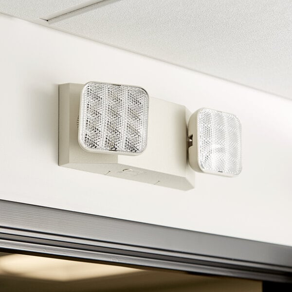 A pair of Lavex white square emergency lights on a wall.