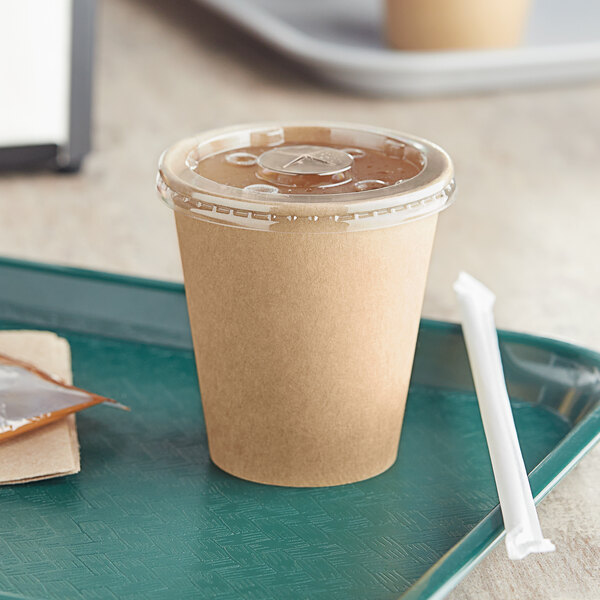 A green tray with a Kraft Choice paper cold cup filled with a brown beverage and a white straw.