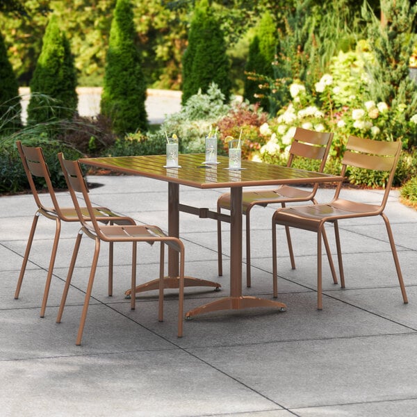 A brown Lancaster Table & Seating outdoor table with chairs on a patio.