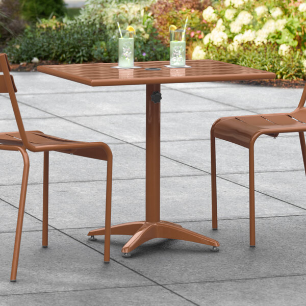 A Lancaster Table & Seating brown table with chairs on an outdoor patio.