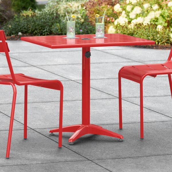 A red Lancaster Table & Seating outdoor table with chairs on a patio.