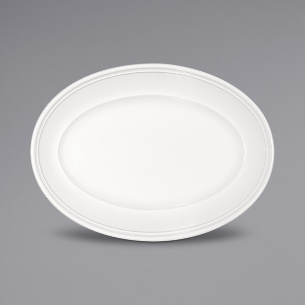 A Bauscher bright white oval porcelain platter with a wide rim on a white background.