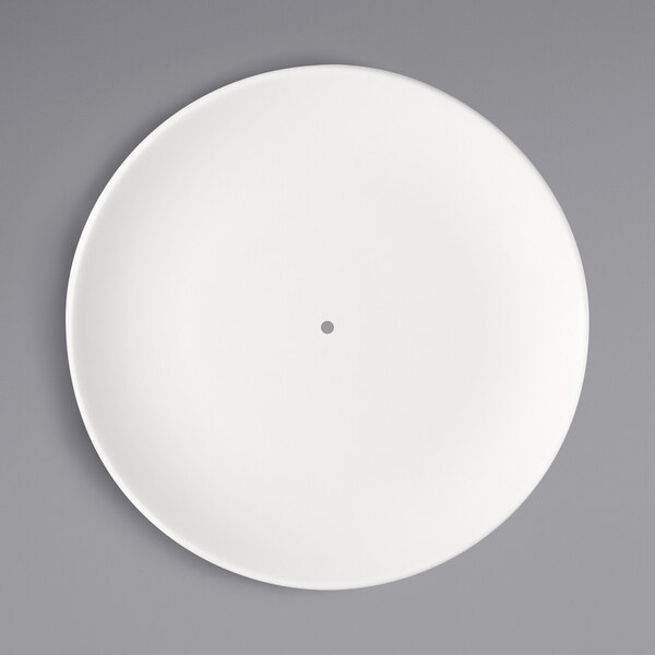 A bright white round porcelain plate with a small hole in the middle.