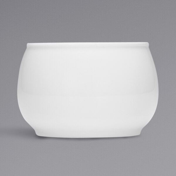 A Bauscher bright white porcelain sugar bowl with a lid on a gray background.