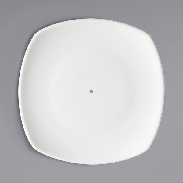 A Bauscher bright white square porcelain plate with a small hole in the middle.