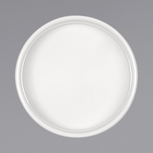 A round bright white porcelain sauce dish with a round rim.