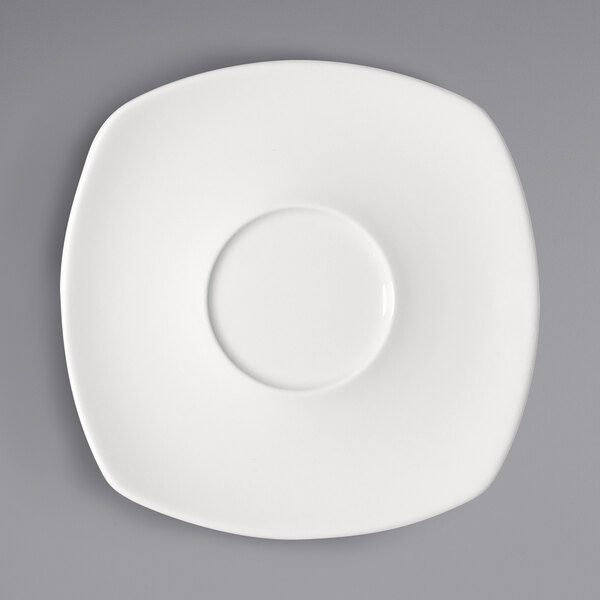 A bright white square porcelain saucer with a circle on it.