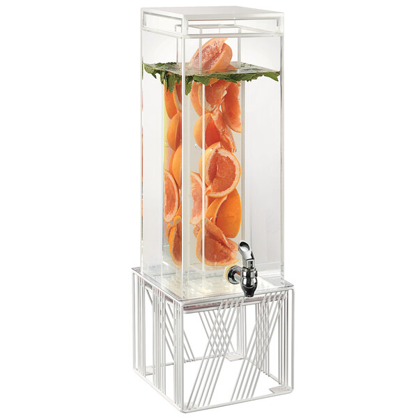 A Cal-Mil square plastic beverage dispenser with an infusion chamber and orange slices in it on a white wire base.