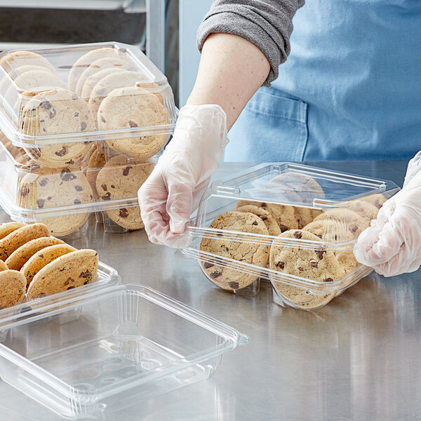 A person holding a Clear PET container of cookies.