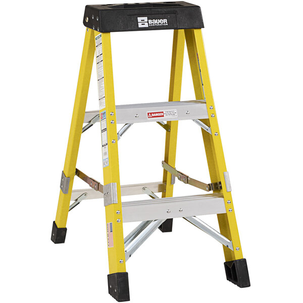 A yellow Bauer Corporation fiberglass step ladder with black and white labels.