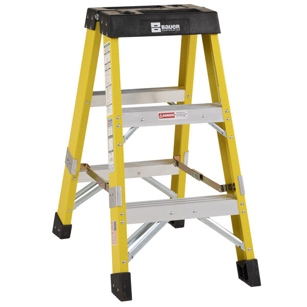A yellow Bauer Corporation fiberglass ladder with black top.