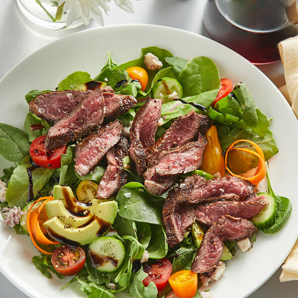 A plate of salad with Warrington Farm Meats coulotte steak, tomatoes, and avocado.