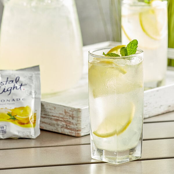 A glass of Crystal Light lemonade with ice and mint leaves.