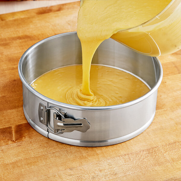 Cake batter being poured into a Choice natural finish aluminum springform cake pan.