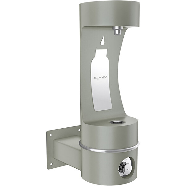 An Elkay grey metal wall mounted bottle filling station over a water fountain with a bottle in the middle.