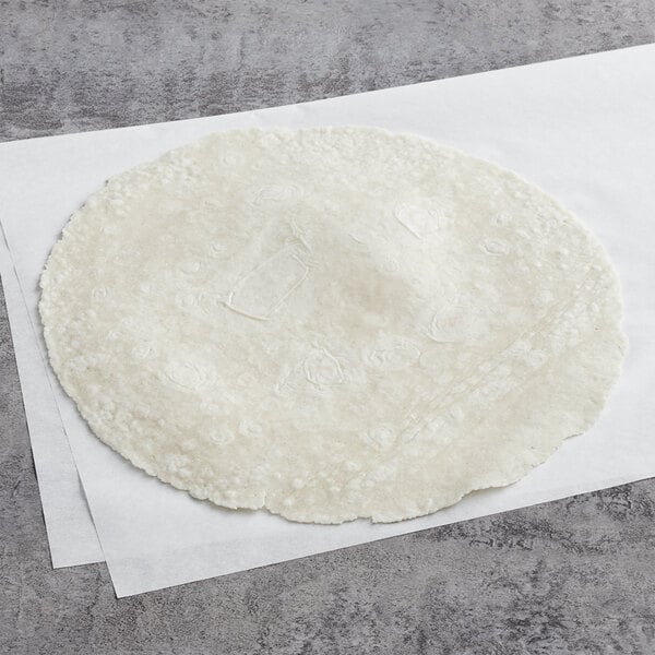 A round white Father Sam's Bakery gluten-free tortilla on a white surface.