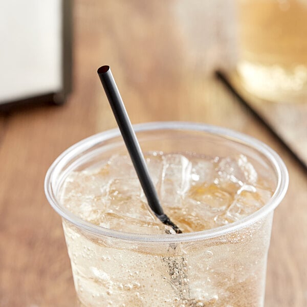 A close-up of a EcoChoice black straw in a clear plastic cup with ice and liquid.