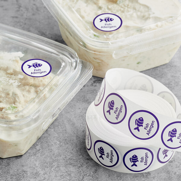 A roll of white Point Plus labels with purple fish and fish allergen images.