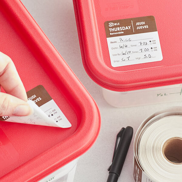 A hand using a Noble Products Thursday food label to label a red container.