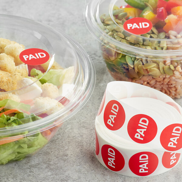 A plastic container of salad with a red Point Plus Paid label on it.