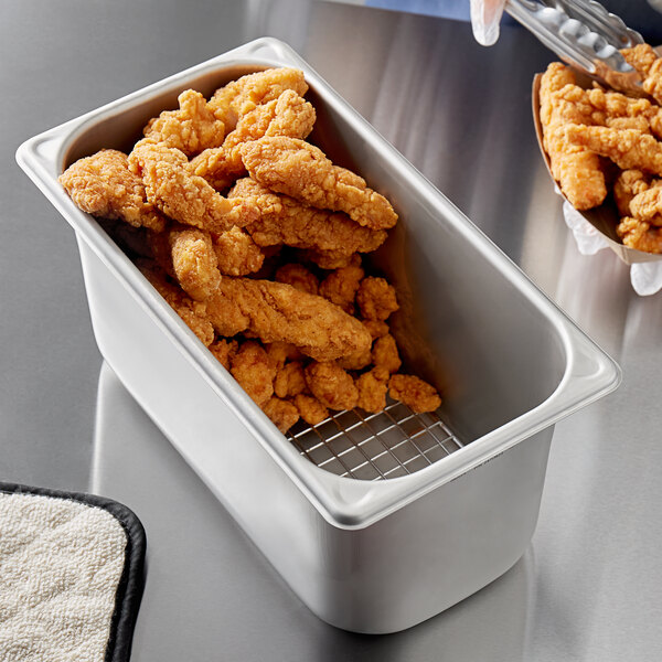 A Vigor stainless steel steam table pan with fried chicken in it.