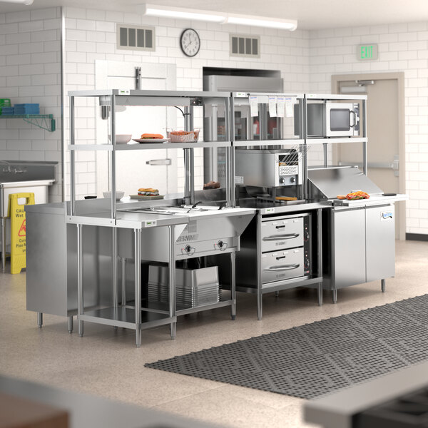 A Chef's Counter serving line package with stainless steel appliances and work tables.