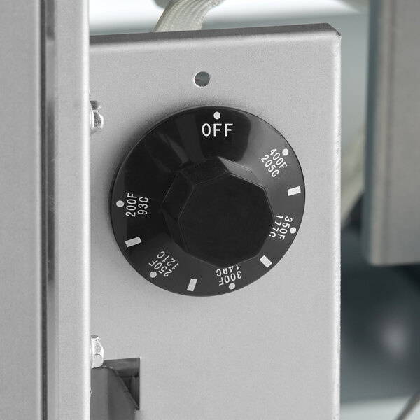 A black temperature control knob on a metal fryer with temperature settings and an off position.