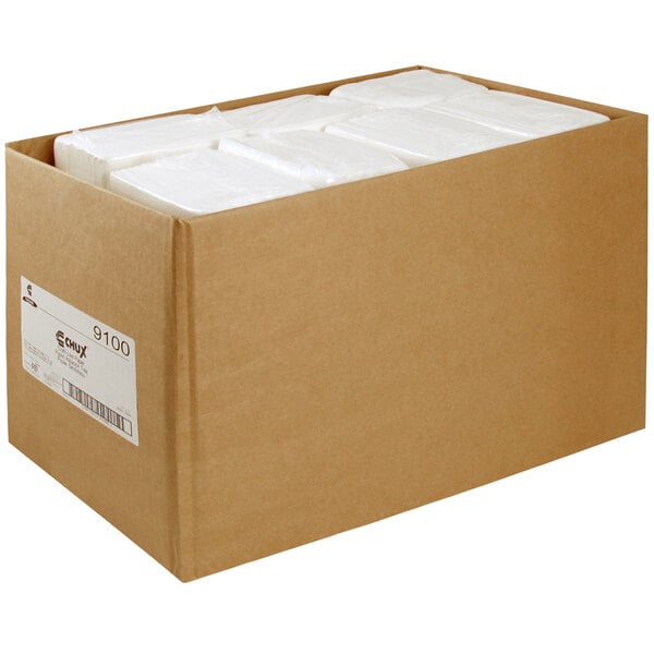 A cardboard box filled with white Chicopee Chux towels.