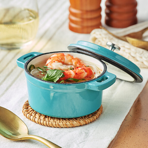 A Valor Aqua Sky enameled cast iron pot with shrimp and vegetables in it.