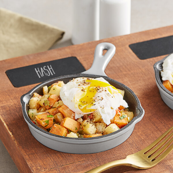 A Valor slate grey enameled cast iron skillet with a poached egg and potatoes.