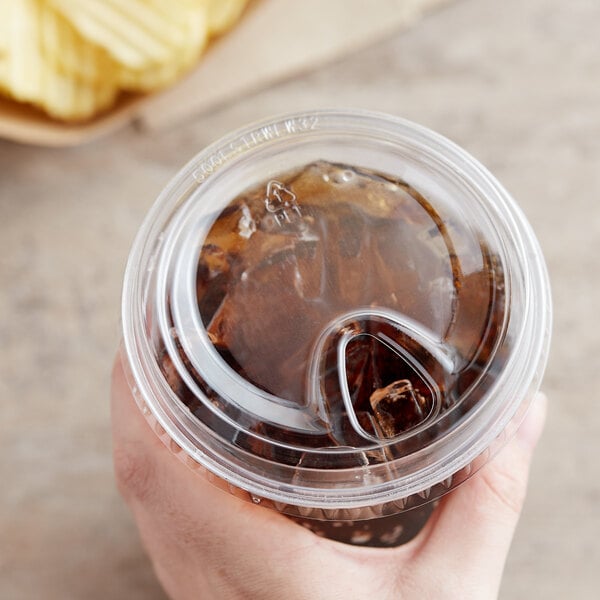 A hand using a Choice plastic cup lid with a drink in it.