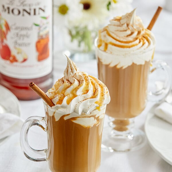 A glass mug of Monin Caramel Apple Butter syrup over coffee with whipped cream.