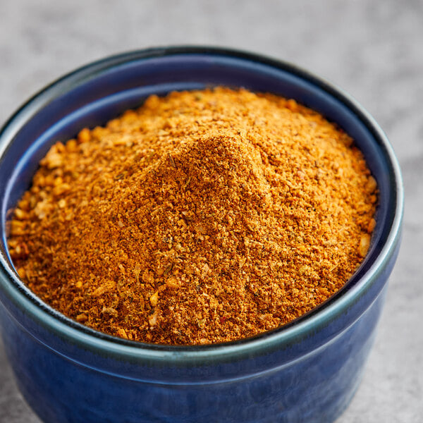 A bowl of Lawry's Smoky Chile and Cumin Rub on a gray surface.