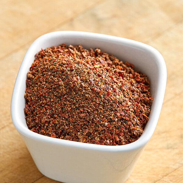 A white bowl of ground red and black spices.