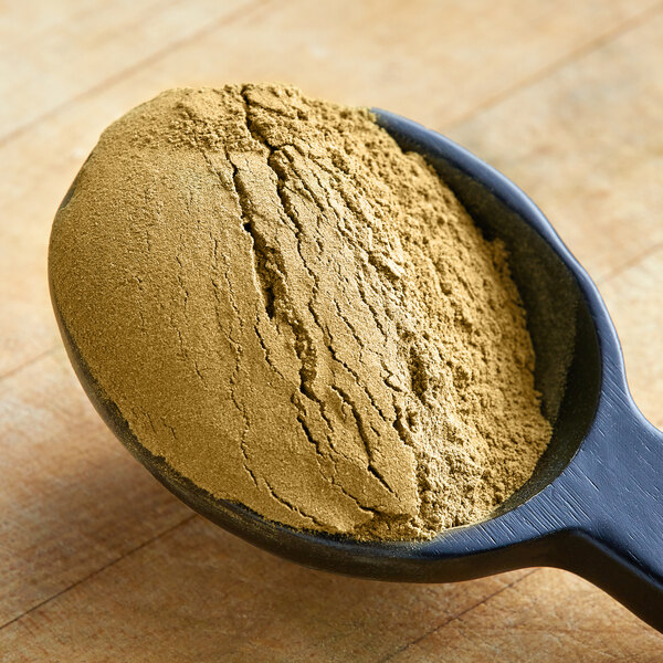 A spoon of brown Zatarain's Gumbo File Seasoning powder.