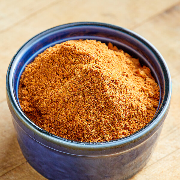 A bowl of Lawry's Taco Seasoning on a wooden table.
