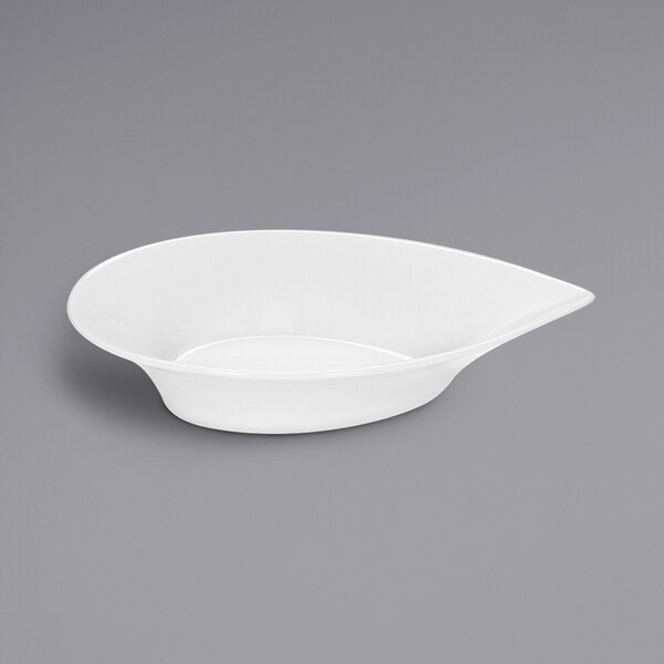 A bright white porcelain sauce boat with a teardrop shape and a spoon.