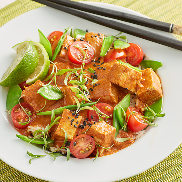 A plate of THAI Kitchen Red Curry Paste with rice, green peppers, and tomatoes.