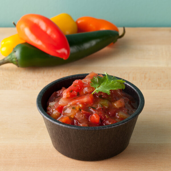 A charcoal polyethylene ramekin filled with salsa and peppers.