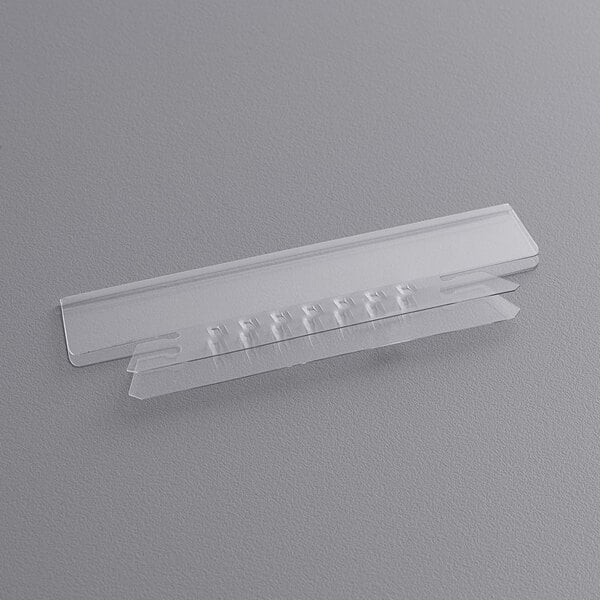 A close-up of a Pendaflex clear plastic insertable tab strip with a small hole.
