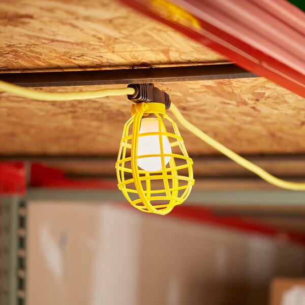 A Voltec U-Ground work light string with plastic cages hanging from a ceiling.