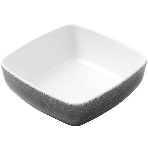A square white bowl with black speckled rim.