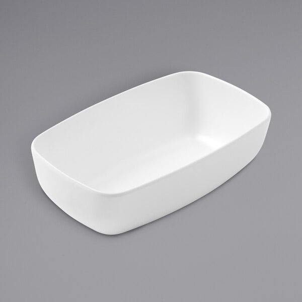 An American Metalcraft white rectangular melamine bowl on a gray surface.