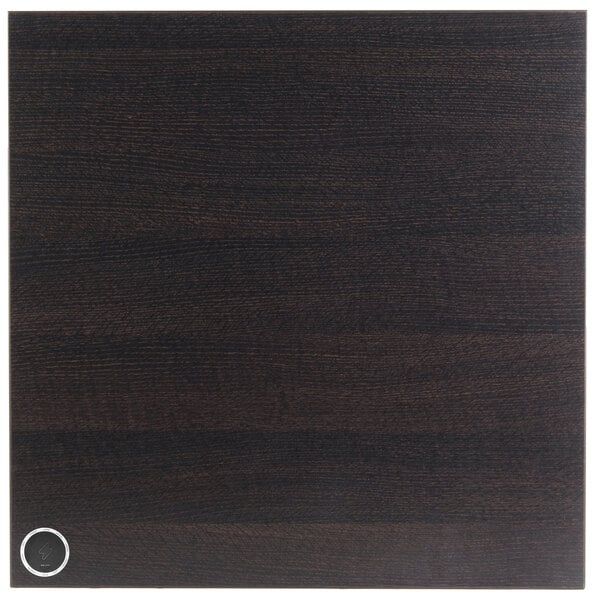 A black wood square tabletop with a round black circle in the middle.