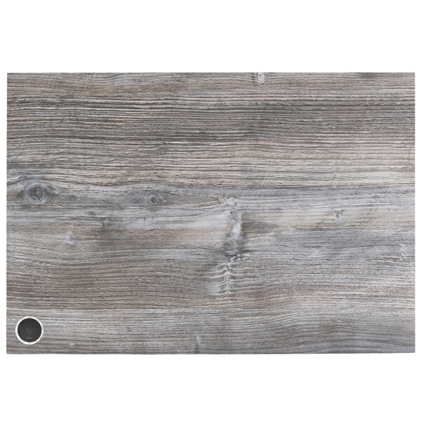 A rectangular wood tabletop with a gray finish and a wireless charger circle in the middle.