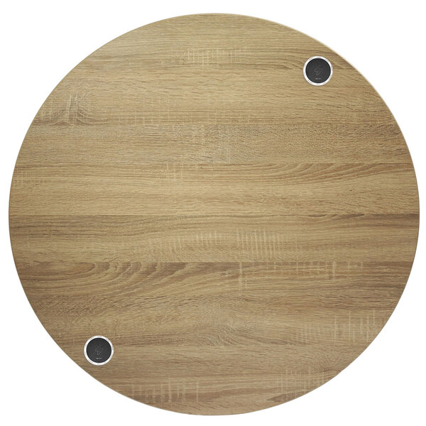 A circular wood table with two holes in it.